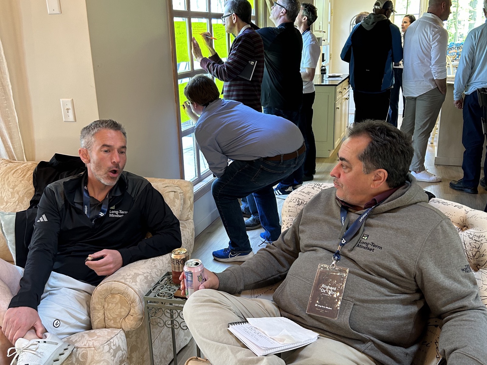 Members talking in the lounge while others write goals on the window