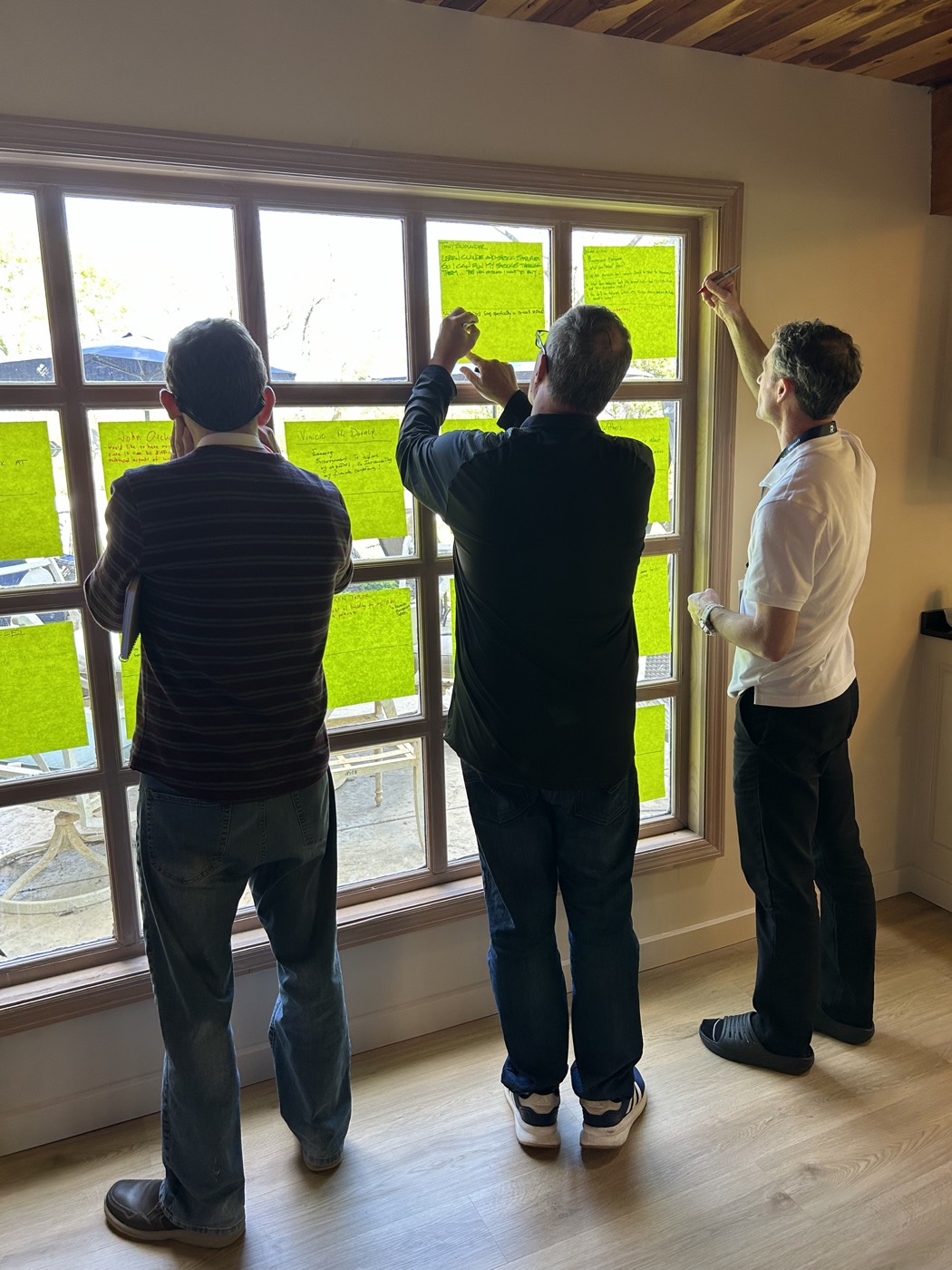 Members writing their investing goals on a window at an in-person gathering